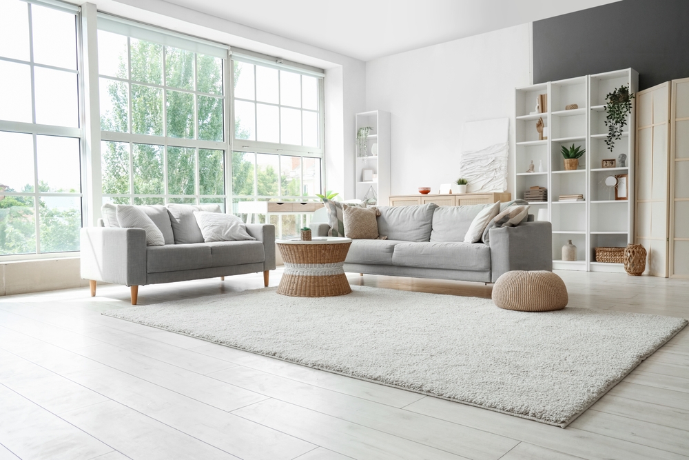 picture of bright living room with big window and neutral coloured furniture